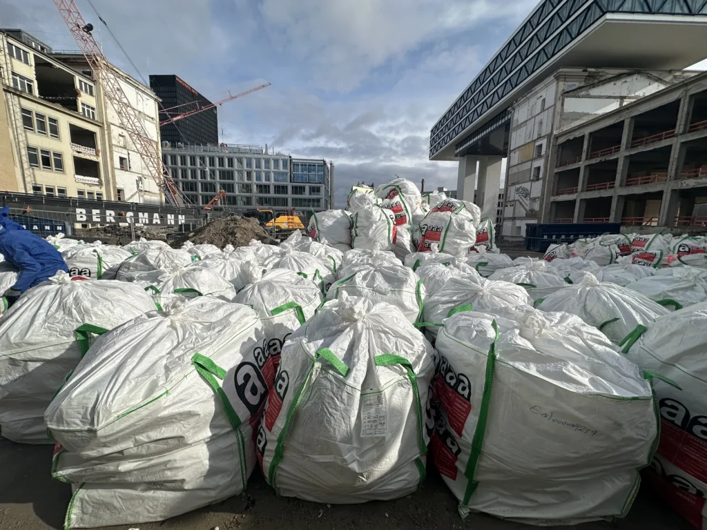 Zahlreiche Big Bags mit Asbestabfällen auf einer Großbaustelle in München während Rückbauarbeiten